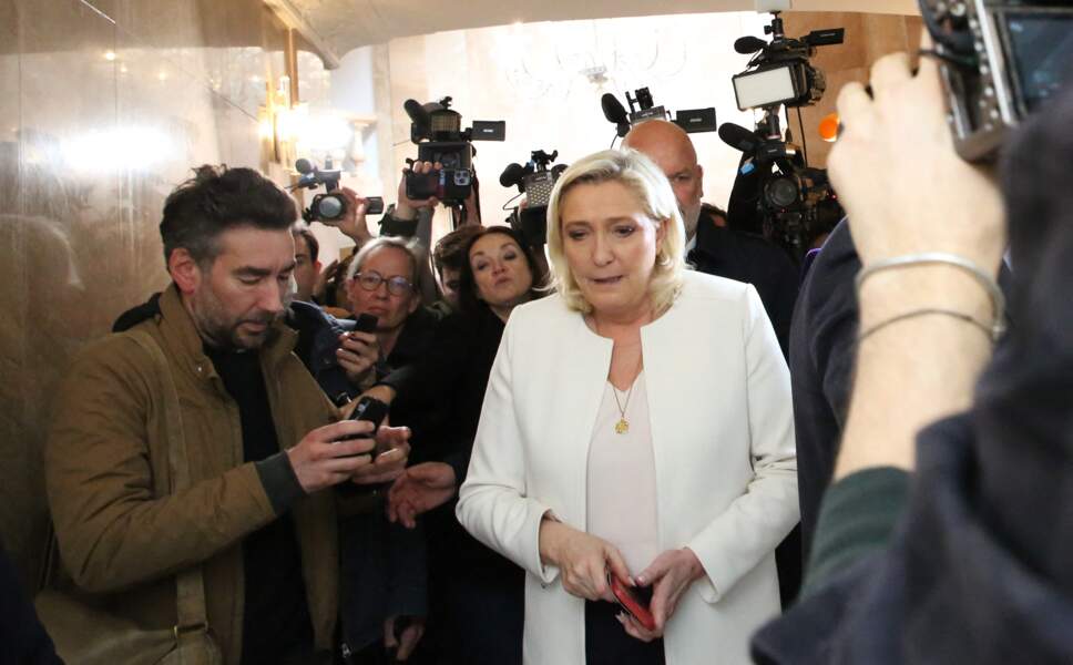 Marine Le Pen et son changement de look depuis 2017. Elle est passée d'un vestiaire sobre à des tenues plus féminines et chaleureuses pour la présidentielle. Ici en tailleur blanc le 13 avril 2022 pour une conférence de presse à Paris. 