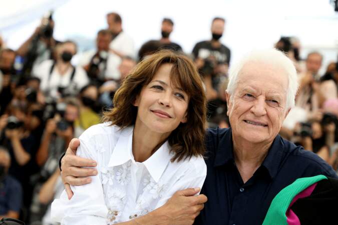Sophie Marceau en Celine accompagnée d'André Dussollier au photocall du film "Tout s'est bien passé" au Festival de Cannes, 2021. Elle est rayonnante avec sa coupe shag.
