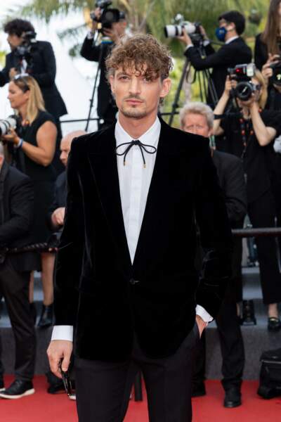 Niels Schneider canon dans un costume noir et chemise blanche sur le tapis rouge à Cannes, ce 28 mai 