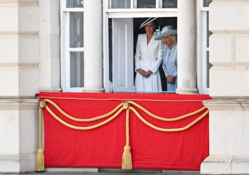 Kate Middleton et Camilla Parker Bowles regardent discrètement la foule depuis une fenêtre de Buckingham lors de la parade militaire "Trooping the Colour" pour le jubilé de platine de la reine Elizabeth II à Londres, le 2 juin 2022