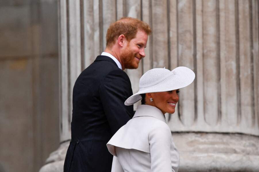 Malgré les huées, le prince Harry et son épouse Meghan Markle gardent le sourire pour faire leur entrée dans la cathédrale Saint-Paul de Londres, le 3 juin 2022.