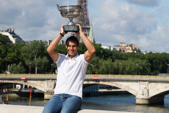 Rafael Nadal soulève la coupe des Mousquetaires, qui pèse près de 14 kilos, sur le pont Alexandre III à Paris, le 6 juin 2022.