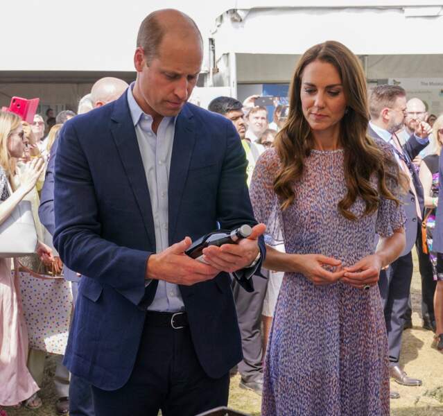 Le prince William s'intéresse à une bouteille d'un commerçant à Newmarket, le 23 juin