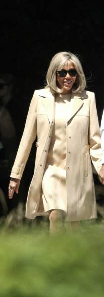 Brigitte Macron choisit un ensemble en cuir composé d'un trench et d'une robe beige Louis Vuitton, le 26 juin 2022.