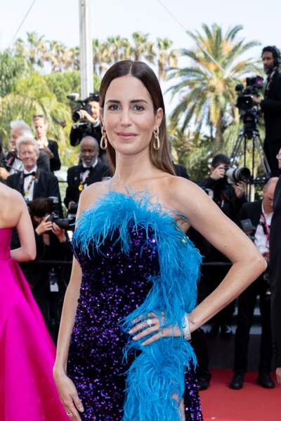 Gala Gonzalez en robe bleue à plumes pour sa montée des marches au festival de Cannes, le 21 mai 2022.