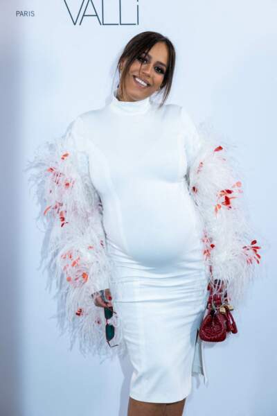 Amel Bent enceinte est rayonnante dans sa robe blanche et rouge à plume, le 7 mars 2022. 