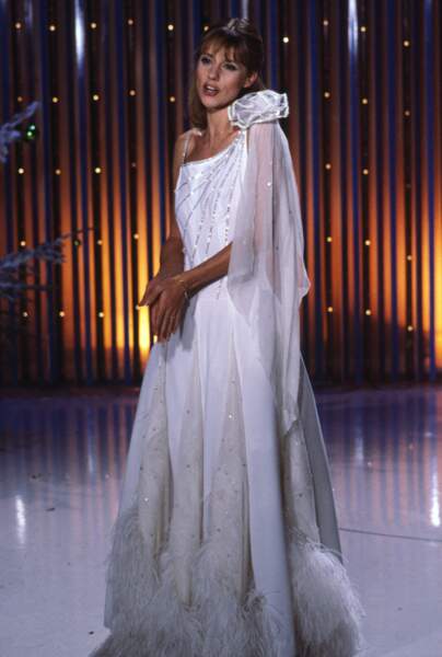 Dorothée angélique dans une robe blanche vaporeuse sertie de plumes en 1985.