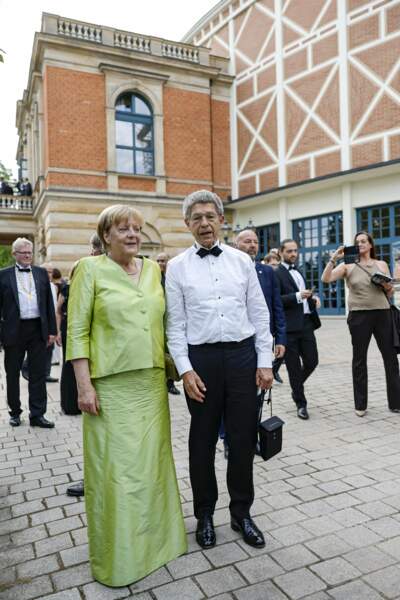 Angela Merkel en costume deux pièces en taffetas brillant, le 25 juillet 2022. 