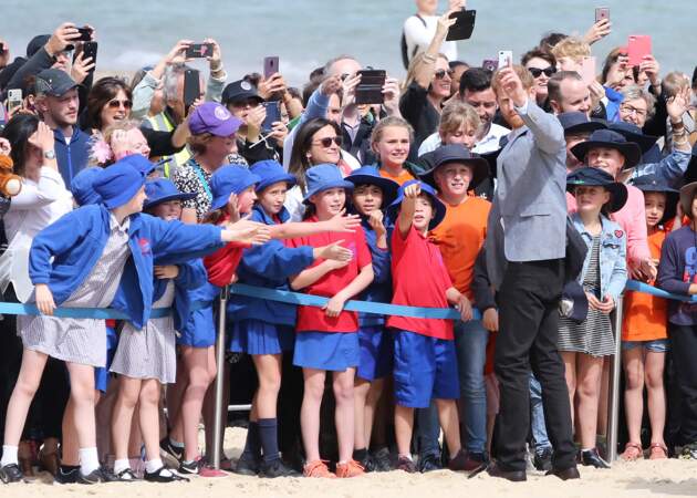 Le prince Harry et Meghan Markle lors d'une rencontre avec des jeunes volontaires pour nettoyer la plage de Melbourne, le 18 octobre 2018