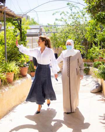 Rania de Jordanie en jupe longue en jean et chemise blanche brodée lors d'une visite en Jordanie, le 26 juillet 2022.