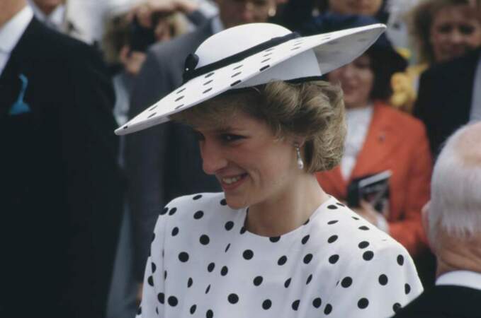 Avec une robe à pois noirs et son chapeau surdimensionné, la princesse Diana est stylée à Epsom en 1986.