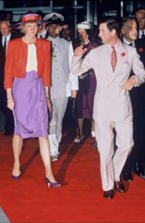 La princesse Lady Di était aux côtés du prince Charles lors d'une visite à Hong kong. Elle associait une jupe violette et une veste courte rouge vive. 