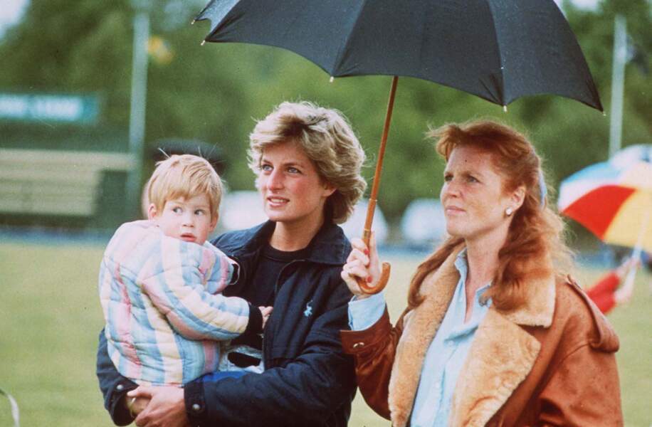 Le prince Harry, âgé de deux ans, lors d'une partie de polo en 1986. Il est dans les bras de la princesse Diana aux côtés de sa tante, Sarah Ferguson.