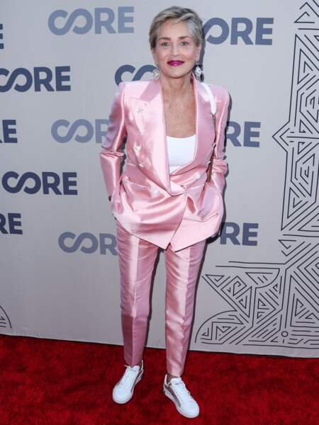 L'actrice Sharon Stone a misé sur un tailleur satiné rose et des baskets blanches au photocall de la soirée Core Gala à Los Angeles le 10 juin.