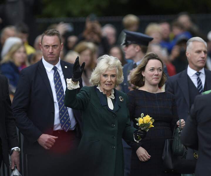 Après avoir reçu un bouquet de fleurs, la reine consort a salué le public massé devant l'abbaye