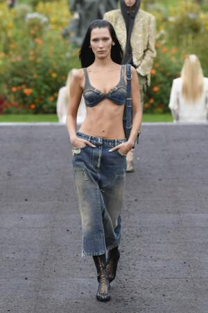 Bella Hadid en brassière et jupe taille basse en jean bleu lors du défilé Givenchy à Paris, le 2 octobre 2022. 