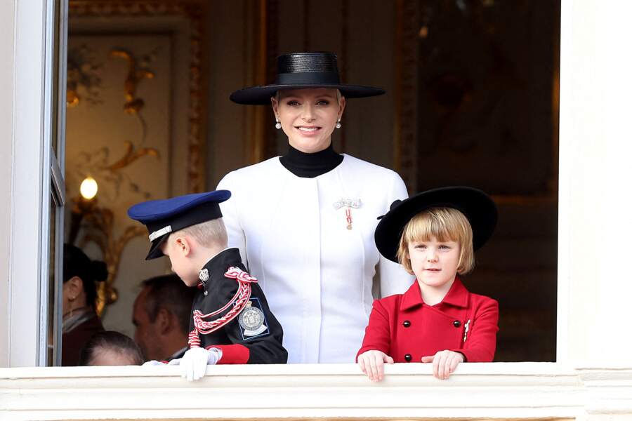 L’épouse du prince Albert a posté sur Instagram un tendre cliché de ses enfants élégamment habillés pour l’occasion : un uniforme de police pour petit garçon de 8 ans et un manteau rouge, couleur officielle, avec le blanc, de la monarchie monégasque pour sa sœur.