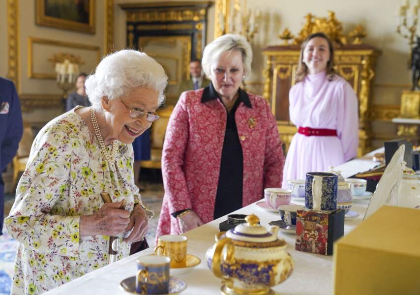 La reine Elisabeth II d'Angleterre parcourt l'exposition d'objets de la société d'artisanat britannique Halcyon Days, pour marquer son jubilé de platine, au château de Windsor