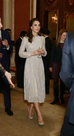 Kate Middleton, en robe midi couleur champagne, lors d'une réception à Buckingham le 27 février 2017