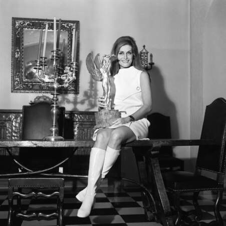 Dalida dans un look à l'esprit sixties en mini-robe blanche et bottes montantes à Paris, en 1968