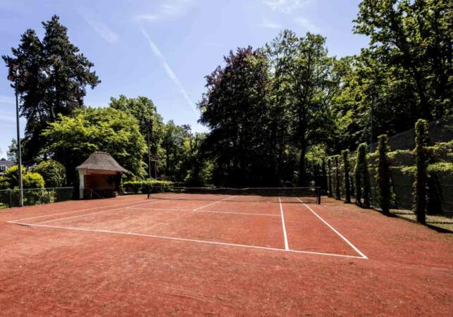 Un terrain de tennis privatif et en terre battue se trouve dans la villa de Marnes-la-Coquette 