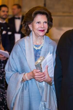 La reine Silvia de Suède recouvre ses épaules d'un châle de la même teinte que sa robe, le 20 janvier 2023
