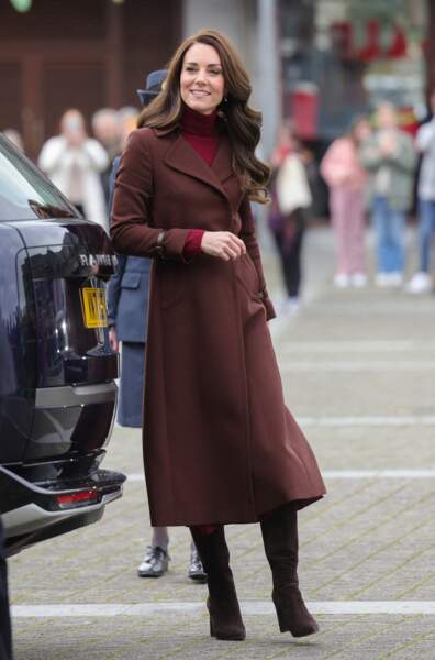 Kate Middleton accorde un manteau chocolat Hobbs London à une robe fuchsia Kiltane à Falmouth, le 9 février 2023