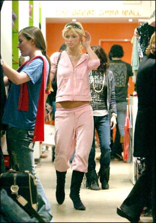 Paris Hilton porte son iconique jogging Juicy Couture rose  taille basse avec des bottes noires et des lunettes oakley sur. la tête