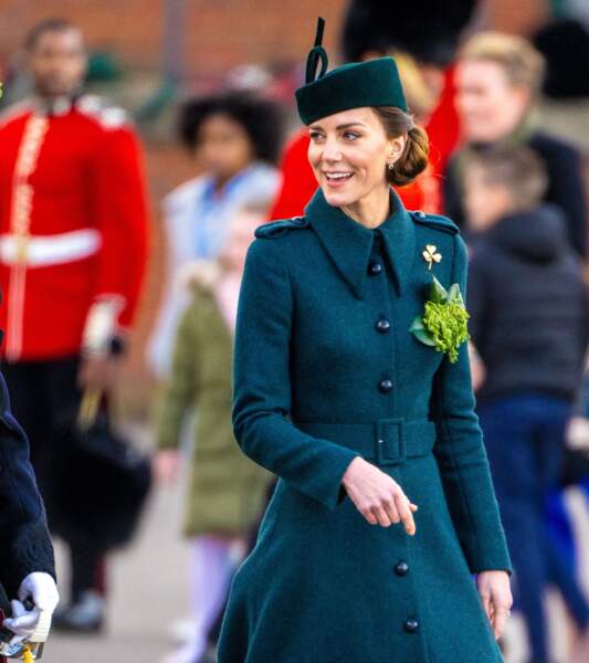 Kate Middleton place une broche en trèfle verte sur sa tenue comme le veut la tradition aux Irish Guards, le 17 mars 2022