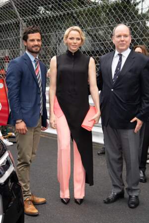 Charlene de Monaco superpose une longue chemise noire à un pantalon rose au Grand Prix de Formule 1 à Monaco en 2019. À travers cette tenue sombre, elle rend hommage au célèbre pilote autrichien Niki Lauda décédé quelques jours avant le Grand Prix 