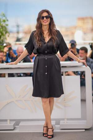 En petite robe noire, Maïwenn immortalise le photocall du film "Jeanne du Barry" lors du 76ᵉ Festival de Cannes, le 17 mai 2023