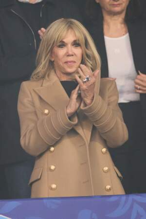 Brigitte Macron enfile son manteau beige lors du match de football de la Coupe de France "Nantes vs Toulouse" au Stade de France à Paris, le 29 avril 2023