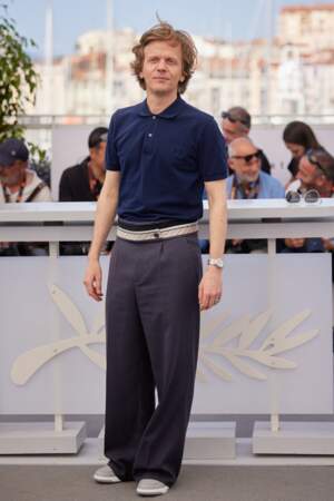 Alex Lutz décontracté-chic en polo bleu marine et pantalon large gris anthracite au Festival de Cannes, le 26 mai 2023