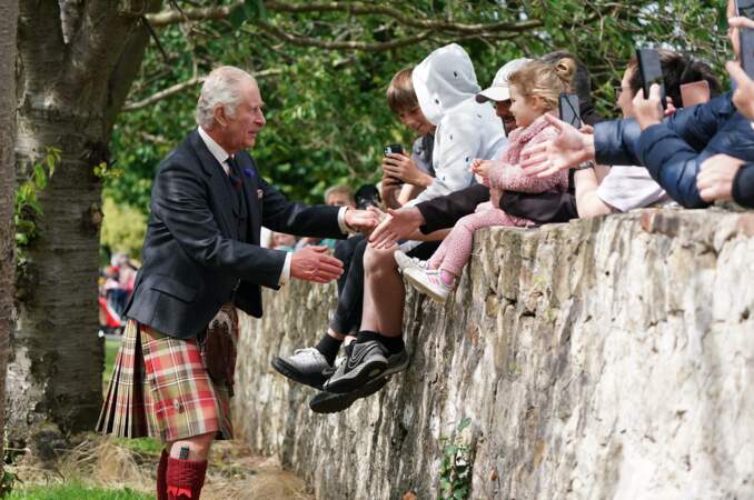 Le roi Charles III salue des enfants venus le rencontrer lors de sa visite à Édimbourg, le lundi 3 juillet 2023.