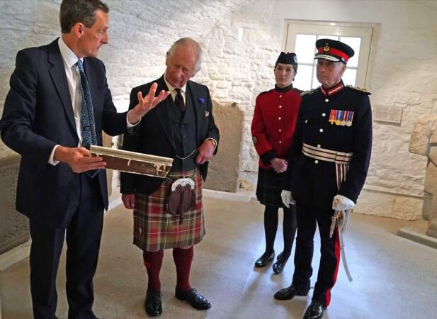 Le roi Charles III écoute attentivement le guide lors de sa visite de la demeure des ducs de Hamilton à Édimbourg, le 3 juillet 2023.
