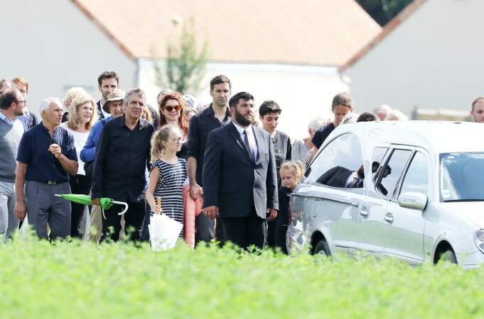 Julien Clerc, sa femme Hélène Grémillon, les trois enfants du défunt, et les proches du journaliste Gérard Leclerc lors de ses obsèques au cimetière des Trois-Moutiers, dans la Vienne, ce 24 août 2023.