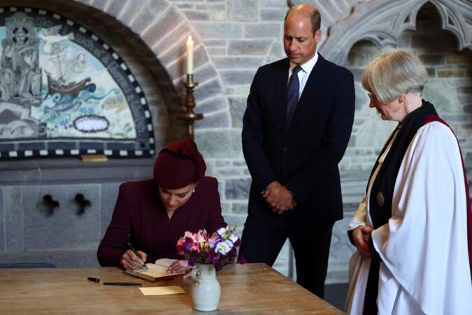 Kate Middleton, princesse de Galles, en train d'écrire un mot dans le registre après avoir assisté à un service religieux marquant le premier anniversaire de la mort de la reine Elizabeth II à la cathédrale St Davids, ce vendredi 8 septembre 2023.