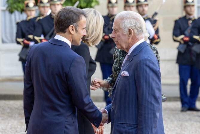 Le président de la république Emmanuel Macron échange une vive poignée de main avec le roi Charles III, à son arrivée à l'Élysée, ce jeudi 21 septembre 2023