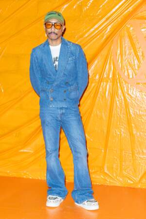 Pharrell Williams en mode 70's en total look jean au défilé Louis Vuitton printemps-été 2024 à Paris, le 2 octobre 2023 