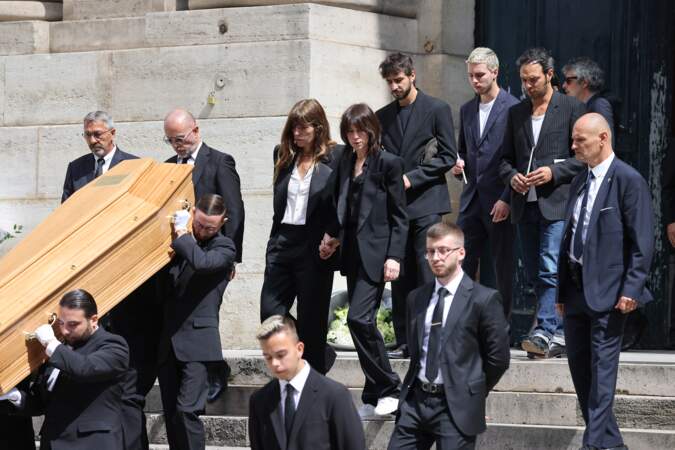Accompagnées de leurs proches, Charlotte Gainsbourg et Lou Doillon sortent de l'église Saint-Roch, le jour des obsèques de Jane Birkin, en l'église Saint-Roch, à Paris, le 24 juillet 2023.