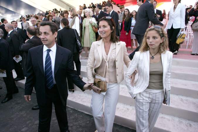 En 2004, Cécilia Attias accompagne son époux pour le 14 juillet, jour de fête nationale, accrochée au bras de sa fille Jeanne-Marie.