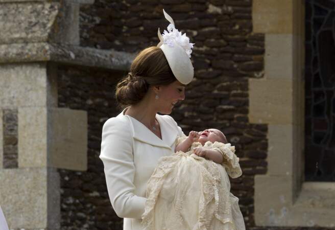 Kate Middleton après le le baptême de la princesse Charlotte qu'elle tient dans les bras, à l'église St. Mary Magdalene à Sandringham, le 5 juillet 2015.