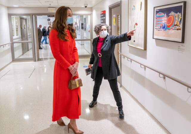 Kate Middleton, duchesse de Cambridge, dans son long manteau rouge et son sac à main en cuir DeMellier, et une paire d'escarpins Ralph Lauren.