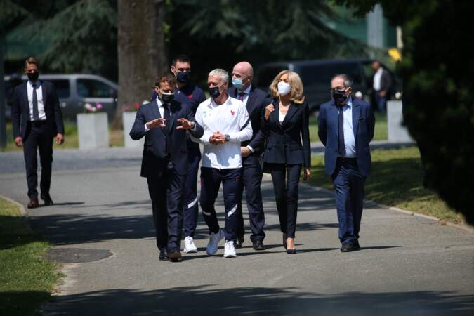 Brigitte Macron très élégante en veste de costume, t-shirt blanc col V et pantalon zippé à Clairefontaine.