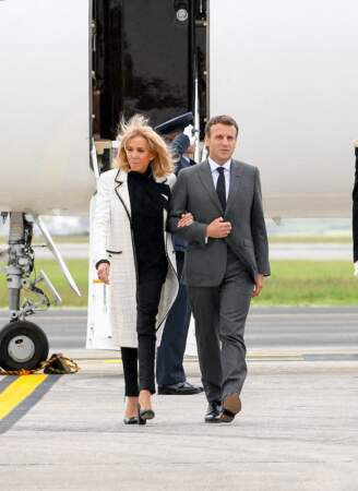 Brigitte Macron offre un look noir et blanc très sobre avec un manteau long en tweed signé Chanel.