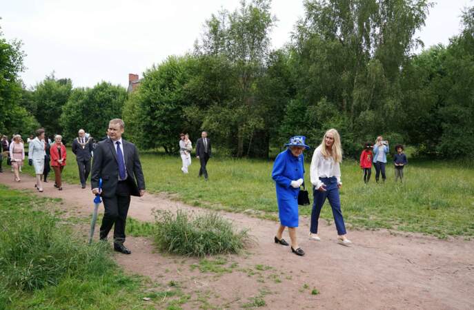 La reine Elizabeth II aux côtés d'Emily Cutts, directrice du Childrends Wood Project lors d'une visite à un projet communautaire à Glasgow, le 30 juin 2021. 