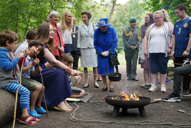 La reine Elizabeth II aux côtés d'Emily Cutts, directrice du Childrends Wood Project lors d'une visite à un projet communautaire à Glasgow, le 30 juin 2021. 