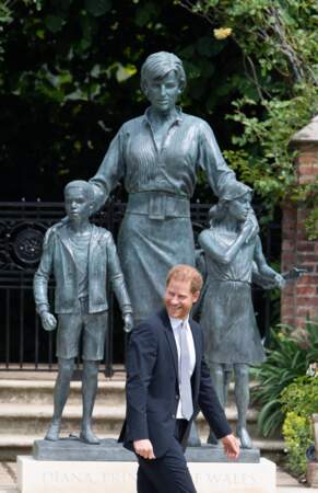 Harry tout sourire devant la statue de Diana, dans les jardins de Kensington Palace à Londres, le 1er juillet 2021. 