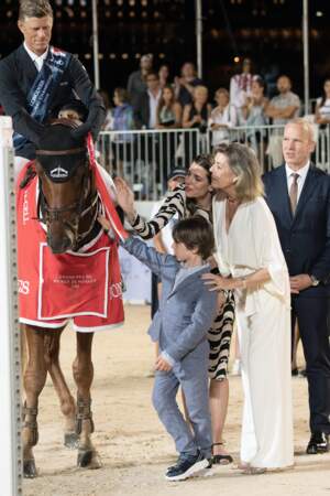 La princesse Caroline, Charlotte Casiraghi et Raphaël Elmaleh admirent un cheval.