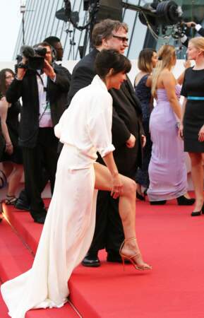 Sophie Marceau dévoilant son jeu de jambes dans sa robe portefeuille en soie blanche Alexandre Vauthier, au Festival de Cannes, en 2015.